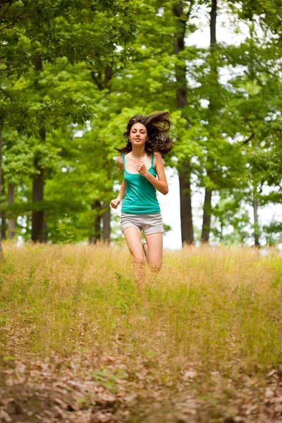 Menina bonita correndo pela floresta — Fotografia de Stock