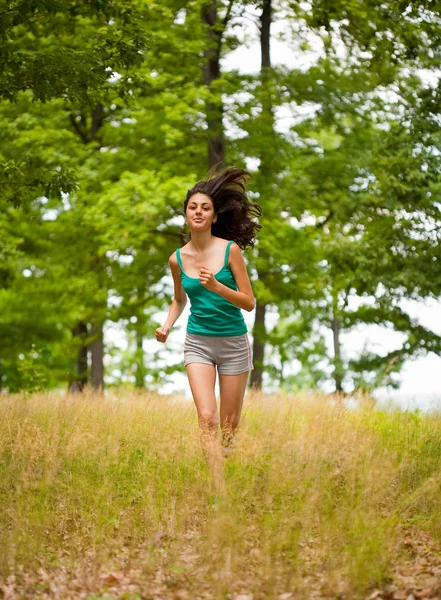 Beautiful girl running through forest — Zdjęcie stockowe