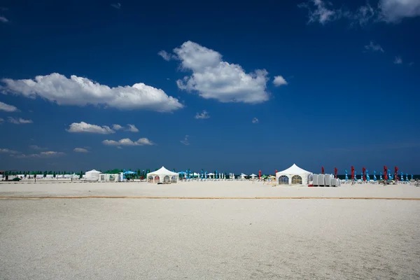 Tents and umbrellas on the beach — Stock Photo, Image