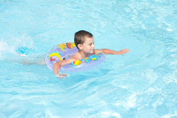 Miúdo bonito nadando na piscina — Fotografia de Stock