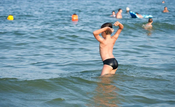 Chłopiec grający w wodzie morskiej — Zdjęcie stockowe