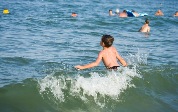 Niño jugando en el agua de mar — Foto de Stock