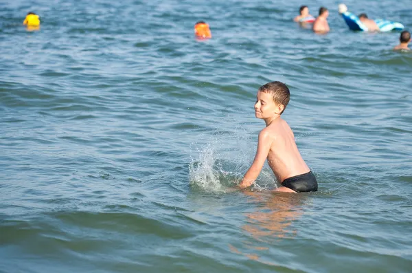 Junge spielt im Meerwasser — Stockfoto