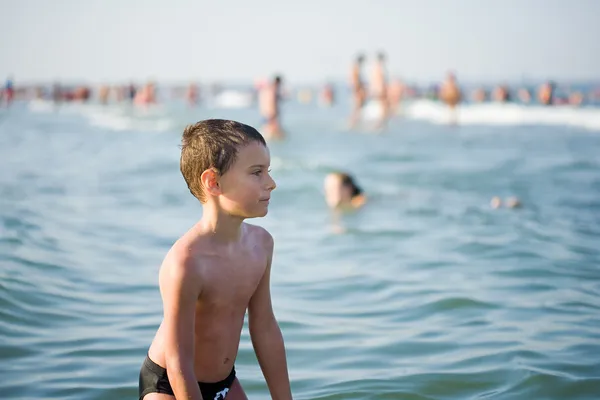 Pojke spelar i havsvatten — Stockfoto