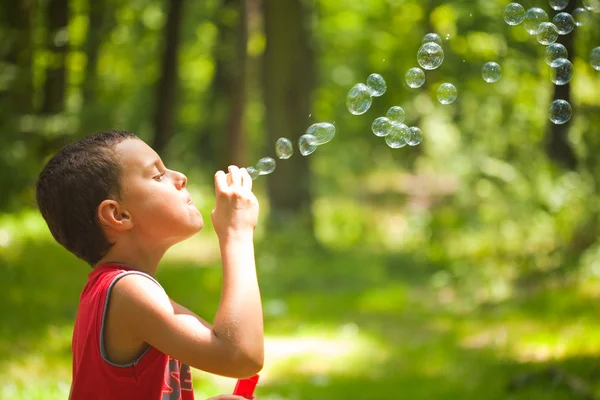 Милый ребенок, пускающий мыльные пузыри — стоковое фото