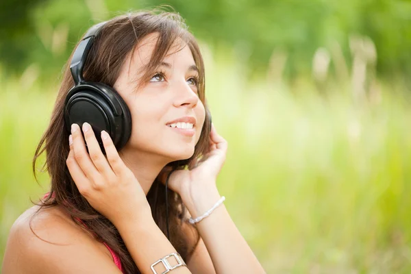 Νεαρή γυναίκα με ακουστικά εξωτερική Φωτογραφία Αρχείου