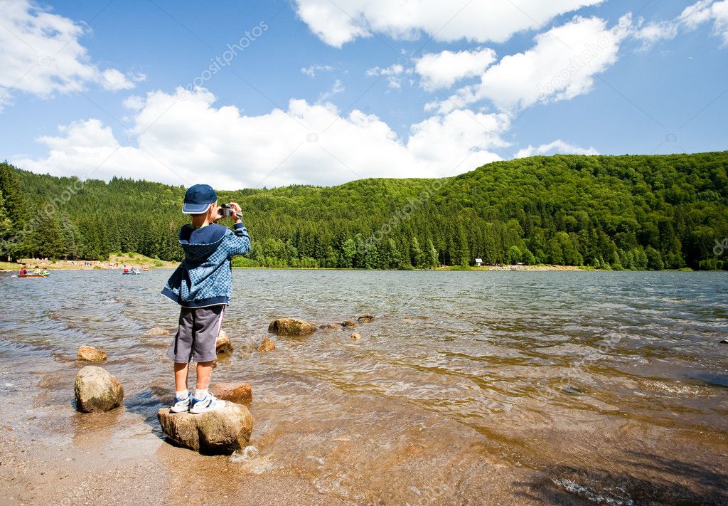 Boy using video camera outdoors