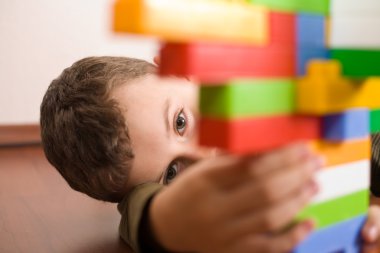 Cute kid playing with cubes clipart