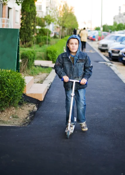 Schattige jongen op een scooter — Stockfoto