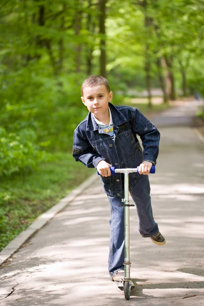 Güzel bir çocuk scooter üzerinde — Stok fotoğraf
