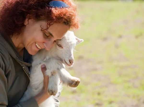 Žena a roztomilé dítě koza — Stock fotografie