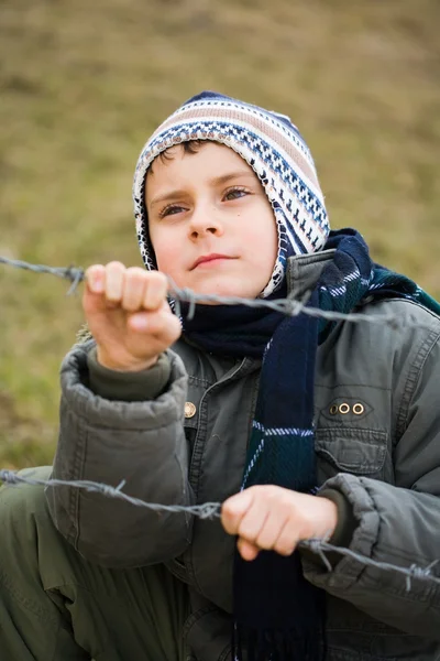 Chłopiec za drutami — Zdjęcie stockowe