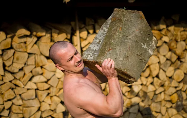 Hombre fuerte levantamiento de troncos —  Fotos de Stock