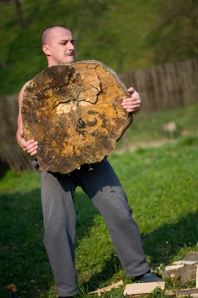 Hombre fuerte levantamiento de troncos —  Fotos de Stock