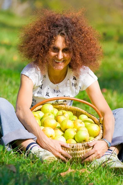 Senhora bonita com uma cesta de maçãs — Fotografia de Stock