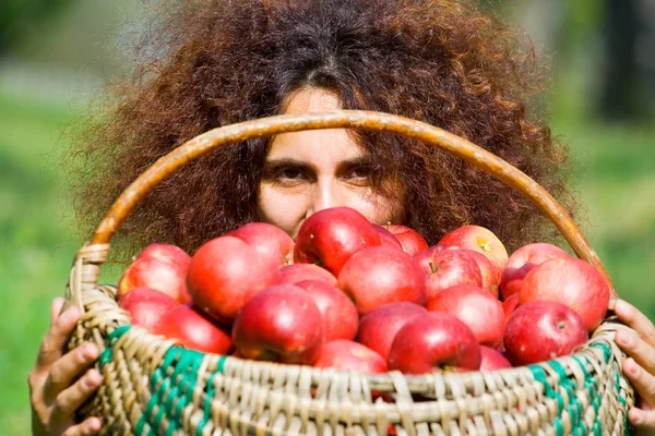 Femme avec panier plein de pommes — Photo