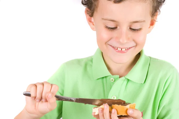 Chłopiec rozprzestrzeniania orzeszków masła na chleb — Zdjęcie stockowe