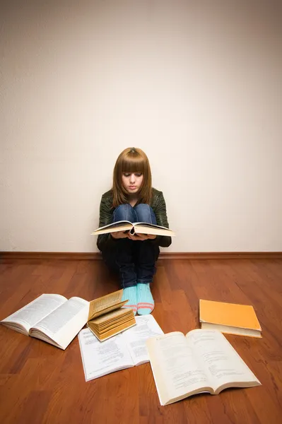 Flicka med böcker på golvet — Stockfoto