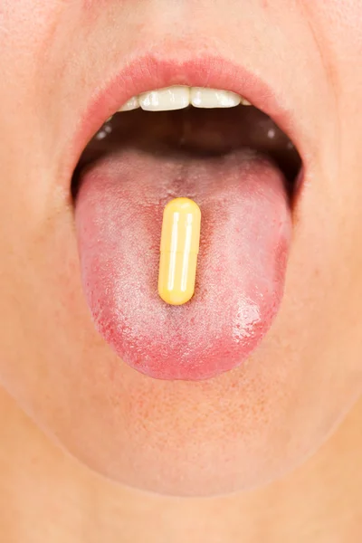 Young woman taking pill — Stock Photo, Image