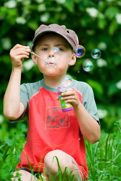 Pojken blåser såpbubblor — Stockfoto