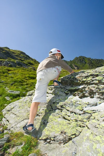 Menino escalando na montanha — Fotografia de Stock