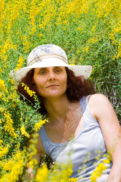 お花畑に帽子を持つ女性 — ストック写真