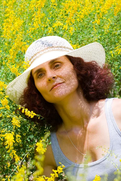 Lady with hat in a flower field — Stock Photo, Image