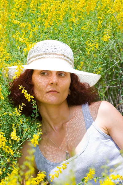 Kobieta w kapeluszu w polu kwiat — Zdjęcie stockowe