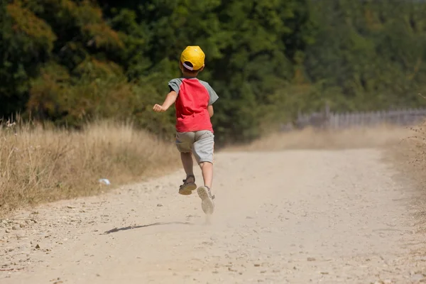 在尘土飞扬的道路上运行的男孩 — 图库照片