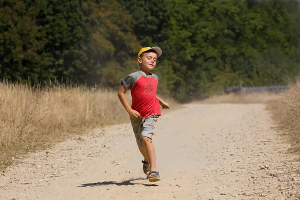 Pojke körs på dammig väg — Stockfoto