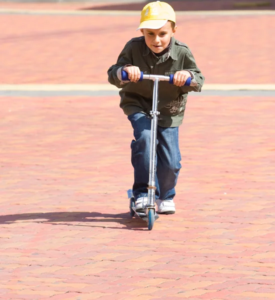 Criança montando uma scooter — Fotografia de Stock