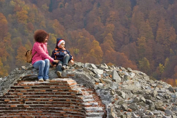Mother and son climb on castle ruins — Stock Photo, Image