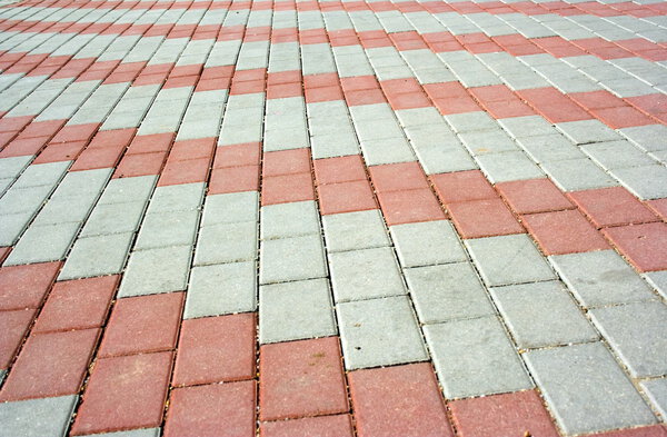 Pavement with a pattern from red and gray rows of concrete blocks