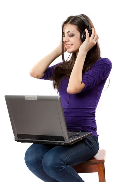 Brunette luisteren muziek van laptop — Stockfoto