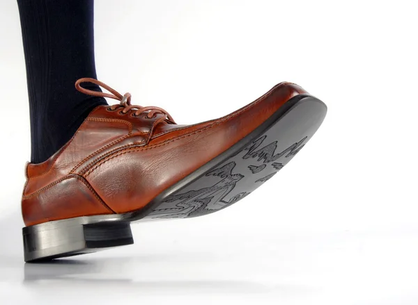 Close-up de sapato masculino pisando no branco — Fotografia de Stock