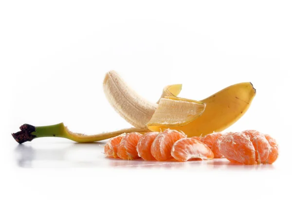 Fatias de banana e tangerina sobre branco . — Fotografia de Stock
