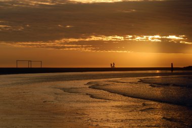 Soccer arcs on the beach at dusk clipart