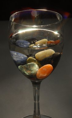 Colored stones in a glass of water clipart