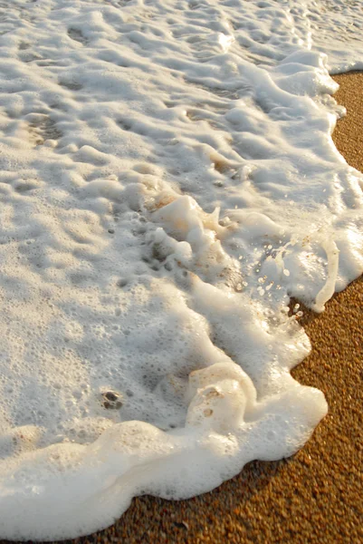 Dalga köpüğü ve kum arka plan — Stok fotoğraf