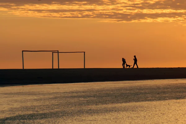 Paar läuft im Morgengrauen am Strand — Stockfoto