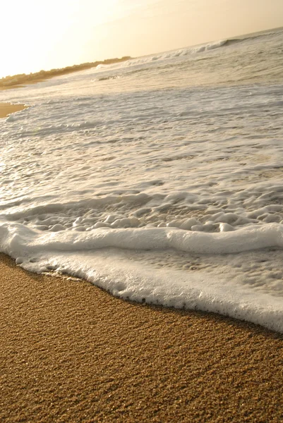 Våg på stranden. skum och sand textur — Stockfoto