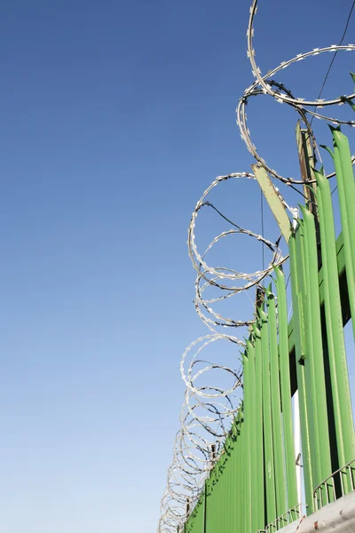 Filo rasoio su recinzione verde — Foto Stock