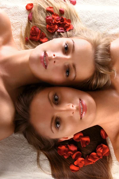 Όμορφες γυναίκες με πέταλα κόκκινο λουλούδι — Φωτογραφία Αρχείου