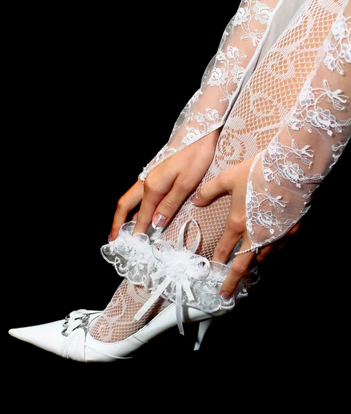 Jarretière de mariage dans les mains sur la jambe — Photo