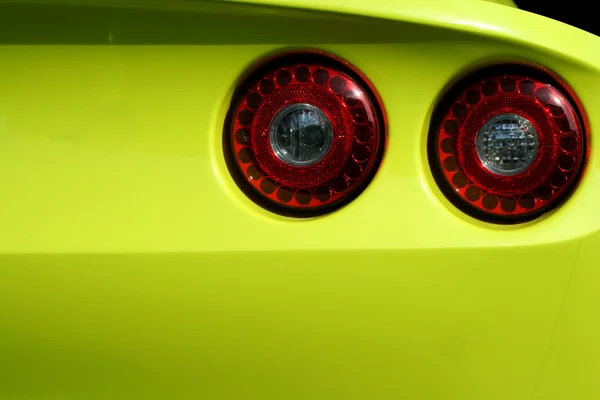 Yellow sports car red tail lights — Stock Photo, Image