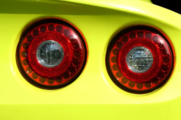 Żółty sportowy samochód czerwony ogon światła — Zdjęcie stockowe