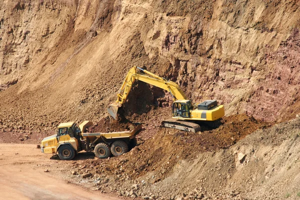 Backhoe and dumptruck at rock quarry — Stock Photo, Image