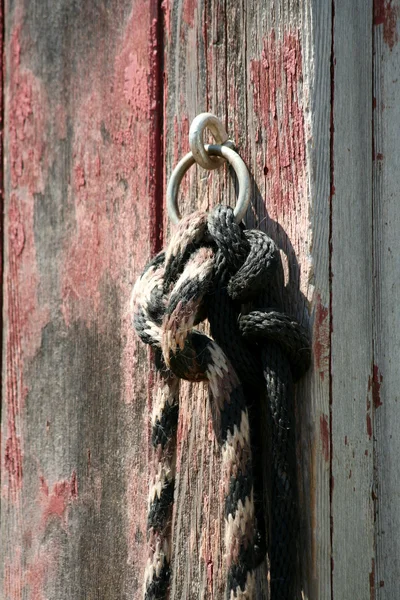 Лошадиная верёвка привязана к старому красному амбару — стоковое фото