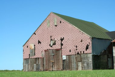 Old barn with grass and blue sky