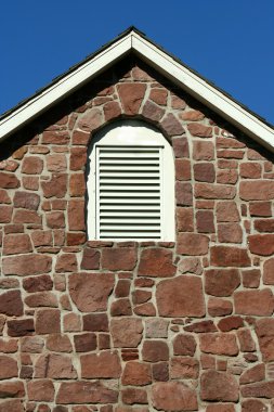 Old stone building with blue sky clipart